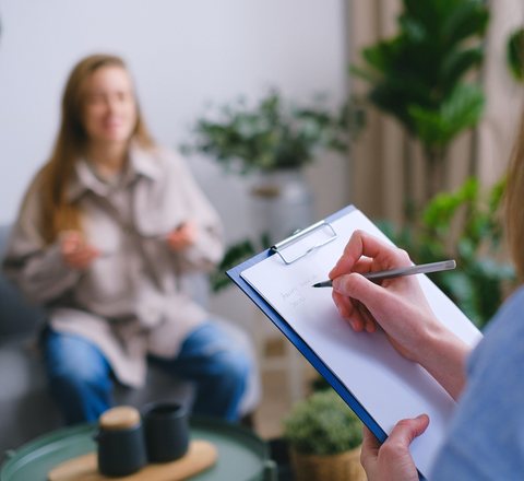 Counsellor taking notes during a relaxed consultation