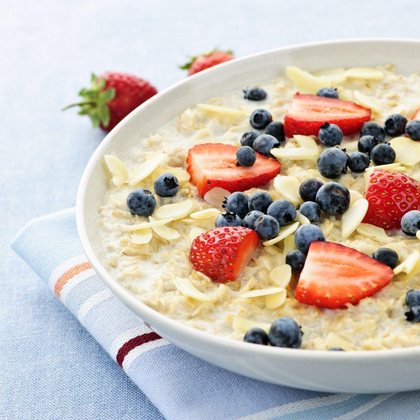Bowl of oatmeal topped with strawberries, blueberries and almonds