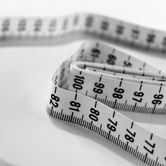 Measuring tape curled on a white surface